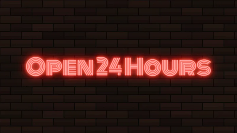Red neon sign reading Open 24 Hours in multi-line diner capitals on a brick wall